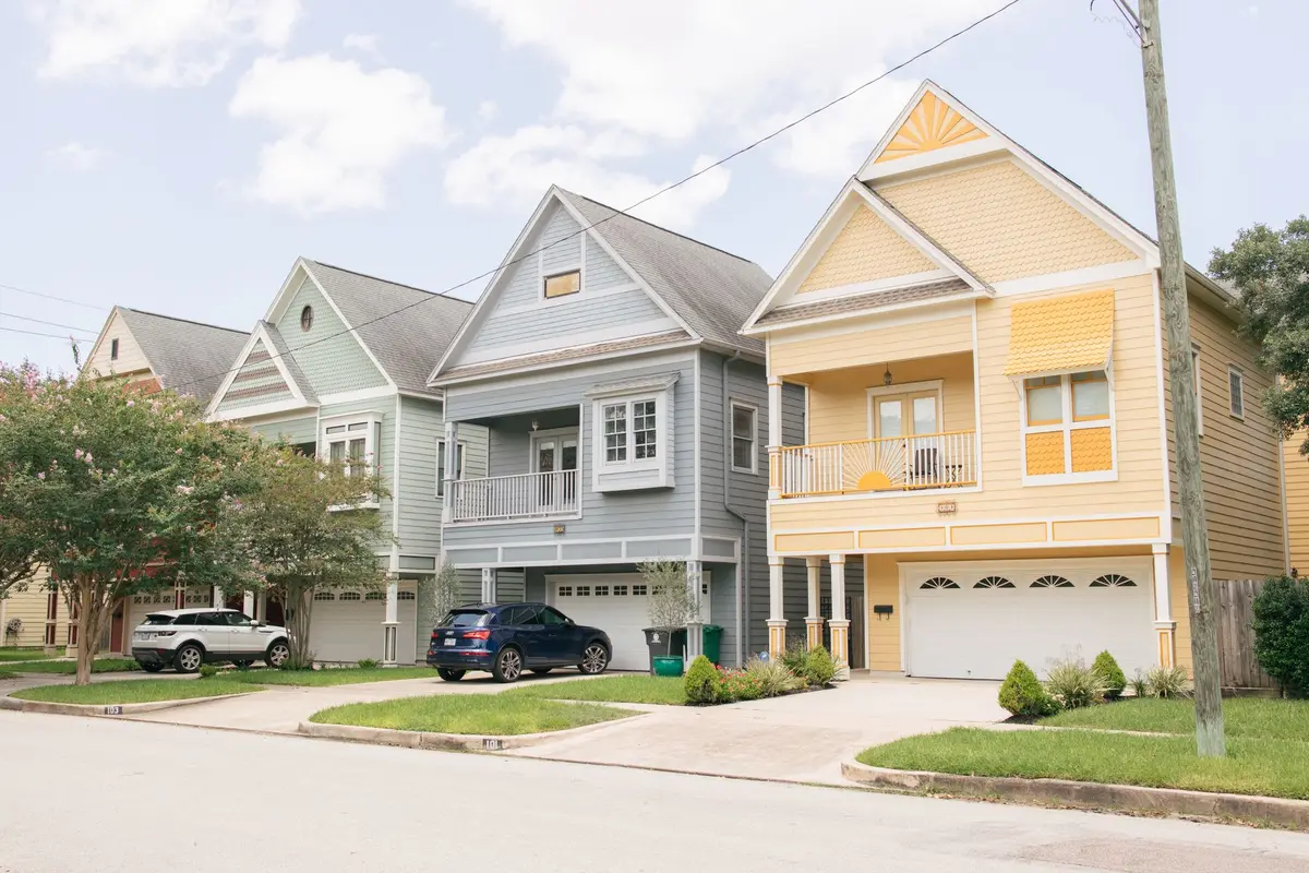 A row of brightly painted houses on a residential street in a Houston neighborhood
